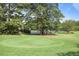Well-maintained tennis courts surrounded by lush green grass and mature trees at 8 Arpege Nw Way, Atlanta, GA 30327