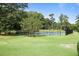 Well-maintained tennis courts surrounded by lush green grass and mature trees at 8 Arpege Nw Way, Atlanta, GA 30327