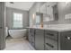 Elegant bathroom with double sink vanity, soaking tub, and herringbone-patterned tile floor at 219 Little John Ne Trl, Atlanta, GA 30309