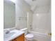 Bathroom featuring shower-tub combination, sink with wood cabinet, and decorative wallpaper at 6502 Wellington Chase Ct, Lithonia, GA 30058