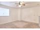Spacious carpeted bedroom featuring a ceiling fan and a window at 6502 Wellington Chase Ct, Lithonia, GA 30058