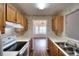 Galley kitchen features wood cabinets, white countertops and stainless steel sink at 6502 Wellington Chase Ct, Lithonia, GA 30058