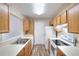 Well-lit kitchen features wood cabinets, white countertops, and stainless steel sink at 6502 Wellington Chase Ct, Lithonia, GA 30058