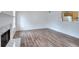 Bright living room featuring a white fireplace, wood-look flooring, and a glimpse into the kitchen at 6502 Wellington Chase Ct, Lithonia, GA 30058