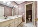 Bathroom with dual sinks, patterned wallpaper, and tiled floors at 3395 Hunters Place, Stonecrest, GA 30038