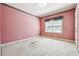 Bedroom with pink walls, white trim, and carpeted floors at 3395 Hunters Place, Stonecrest, GA 30038