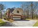 View of the home's side and attached garage, showcasing the driveway and surrounding landscaping at 3395 Hunters Place, Stonecrest, GA 30038