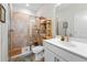 Modern bathroom featuring a tiled shower, framed shower door, vanity with sink, and decorative shelving at 6023 Skellig St, Norcross, GA 30071