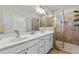Modern bathroom showcasing a dual sink vanity and a glass-enclosed shower with tiled walls at 6023 Skellig St, Norcross, GA 30071