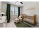 Adorable Bedroom with gold baby bed, gray walls, a plush seat, and decorative curtains at 6023 Skellig St, Norcross, GA 30071