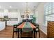 Dining room featuring wood floors, a long wood table, and views into the kitchen at 6023 Skellig St, Norcross, GA 30071