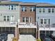 Exterior shot of townhomes showcasing decks, brick accents, and garage parking at 6023 Skellig St, Norcross, GA 30071