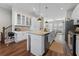 Spacious kitchen with white cabinetry, granite countertops, stainless steel appliances, and an island with seating at 6023 Skellig St, Norcross, GA 30071