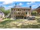 Expansive backyard featuring a large deck, patio, stone retaining wall, and lush green lawn at 840 Stonehaven Ln, Alpharetta, GA 30005