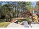 Serene backyard setting with mature trees, a stone patio, comfortable seating, and a lush lawn at 840 Stonehaven Ln, Alpharetta, GA 30005