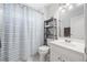 Well-lit bathroom with a shower featuring a striped curtain, a white sink, and tile flooring at 840 Stonehaven Ln, Alpharetta, GA 30005