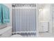 Bathroom with blue and white striped shower curtain, white tile flooring, and light gray wall paint at 840 Stonehaven Ln, Alpharetta, GA 30005