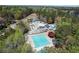 Aerial view of a community pool, waterslide, and clubhouse surrounded by lush greenery and a lake at 840 Stonehaven Ln, Alpharetta, GA 30005