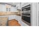 Modern kitchen boasting stainless steel ovens and granite countertops and white cabinets at 840 Stonehaven Ln, Alpharetta, GA 30005
