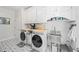 Well lit laundry room with washer, dryer, stainless sink, and lots of cabinet space at 840 Stonehaven Ln, Alpharetta, GA 30005