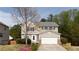 Traditional two-story home with a manicured lawn, blooming tree, and two-car garage at 1924 Sweet Flag Rd, Lawrenceville, GA 30045
