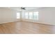 Spacious living room featuring hardwood floors, three large windows and a ceiling fan at 1924 Sweet Flag Rd, Lawrenceville, GA 30045