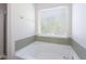 Modern bathroom with a deep soaking tub and tile surround, perfect for relaxation at 1924 Sweet Flag Rd, Lawrenceville, GA 30045