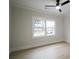 Bright bedroom featuring a ceiling fan, hardwood floors, and a large window at 3128 Cedar St, Scottdale, GA 30079