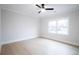 Bright bedroom featuring a ceiling fan, hardwood floors, and a large window at 3128 Cedar St, Scottdale, GA 30079