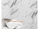 Close up of marble tile shower with stacked towels and natural sponge on the shelf at 3128 Cedar St, Scottdale, GA 30079