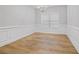 Dining area with wainscoting, hardwood flooring and large picture window at 5125 Cactus Cove Ln, Buford, GA 30519