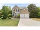Charming two-story home boasts a two-car garage, manicured lawn, and inviting curb appeal at 7040 Magnolia Park Ln, Norcross, GA 30093
