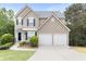 Attractive home with a two-car garage, manicured lawn, and welcoming front door at 7040 Magnolia Park Ln, Norcross, GA 30093