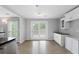 Open kitchen with white cabinets, hardwood floors and view to a deck at 7040 Magnolia Park Ln, Norcross, GA 30093