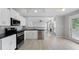 Modern kitchen with stainless steel appliances, white cabinets, and an open view to the living room at 7040 Magnolia Park Ln, Norcross, GA 30093
