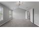 Bright main bedroom showcasing neutral colors, plush carpet, large windows, and vaulted ceiling at 7040 Magnolia Park Ln, Norcross, GA 30093
