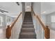 Carpeted staircase with wood railings connecting multiple floors of the home at 7040 Magnolia Park Ln, Norcross, GA 30093