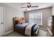 This bedroom features a wooden bed frame, ceiling fan, natural light, and warm neutral paint at 2006 Hubbard Ct, Villa Rica, GA 30180
