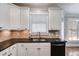 Well-lit kitchen featuring white cabinets, granite countertops and black appliances at 2006 Hubbard Ct, Villa Rica, GA 30180