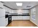 Well-lit kitchen with white cabinets, black countertops, and stainless steel appliances at 2006 Hubbard Ct, Villa Rica, GA 30180