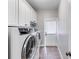 Bright laundry room with washer, dryer, white cabinets and tile floors at 2006 Hubbard Ct, Villa Rica, GA 30180