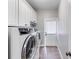 Bright laundry room with washer, dryer, white cabinets and exterior door at 2006 Hubbard Ct, Villa Rica, GA 30180