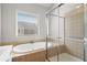 A modern bathroom featuring a soaking tub and glass-enclosed shower at 2620 Milford Ln, Alpharetta, GA 30009