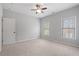 This carpeted bedroom features a ceiling fan and windows with natural light at 2620 Milford Ln, Alpharetta, GA 30009