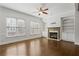 Sunlit living room featuring a fireplace, built-in bookshelves, hardwood floors, and a ceiling fan at 2620 Milford Ln, Alpharetta, GA 30009