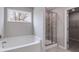 Modern bathroom showcasing a soaking tub, separate glass-enclosed shower, and view to the outside at 804 Trestle Creek Ct, Temple, GA 30179