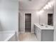 Bright bathroom featuring double vanity with quartz countertop, framed mirrors, and glass-enclosed shower at 804 Trestle Creek Ct, Temple, GA 30179