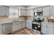 Updated kitchen with stainless steel appliances, granite countertops, and gray cabinetry at 804 Trestle Creek Ct, Temple, GA 30179