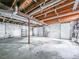 The basement has concrete floors, exposed wood beams, and a garage door at 1090 Tanglewood Trl, Woodstock, GA 30189