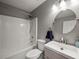 Neat bathroom featuring a shower-tub combination, a sink with a round mirror, and tiled floors at 2112 Little River Dr, Suwanee, GA 30024